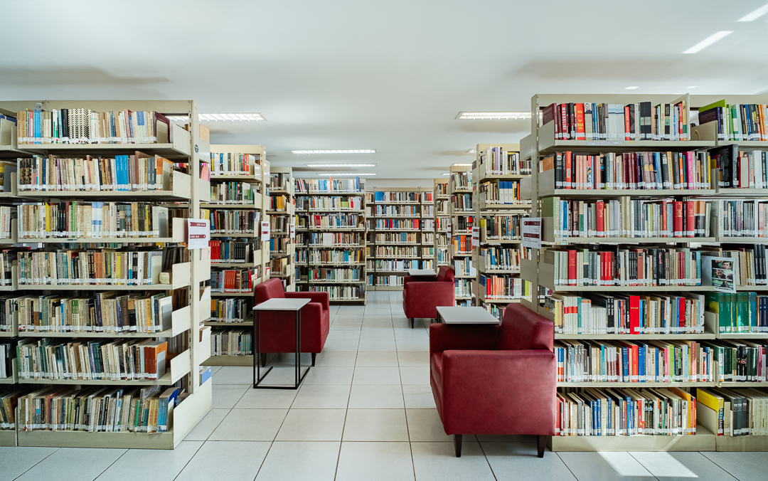 Biblioteca da FESPSP com estantes de acervo especializado e poltronas de leitura