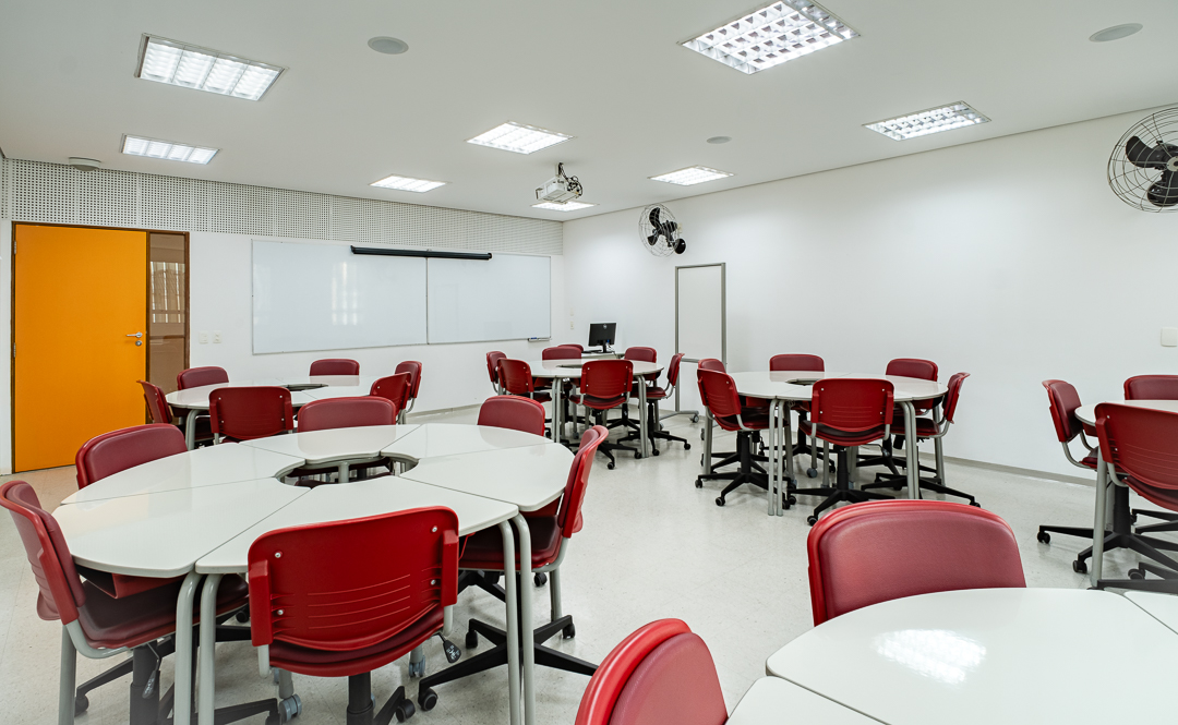 Sala de aula da FESPSP com mesas modulares e cadeiras vermelhas